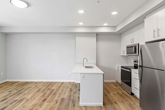 A kitchen with a white island and stainless steel appliances.