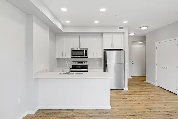 A kitchen with white cabinets and appliances.