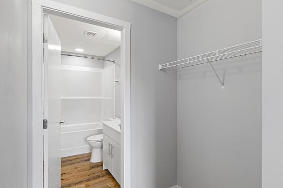 A white bathroom with a toilet, sink, and a walk-in shower.