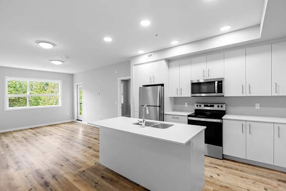 A modern kitchen with white cabinets and stainless steel appliances.