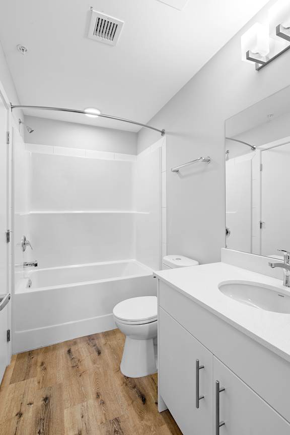 A white bathroom with a toilet, sink, and bathtub.