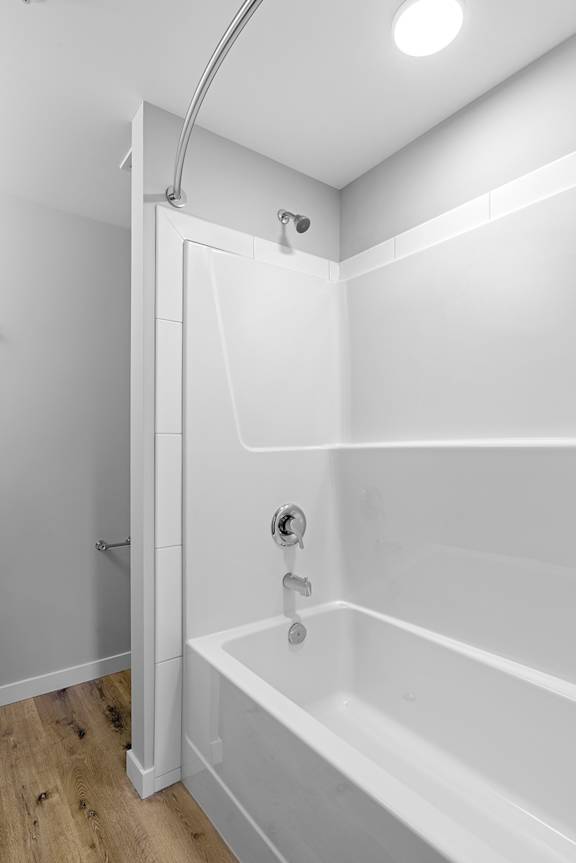 A white bathroom with a tub and shower.