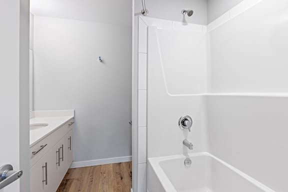 A white bathroom with a tub and a shower.