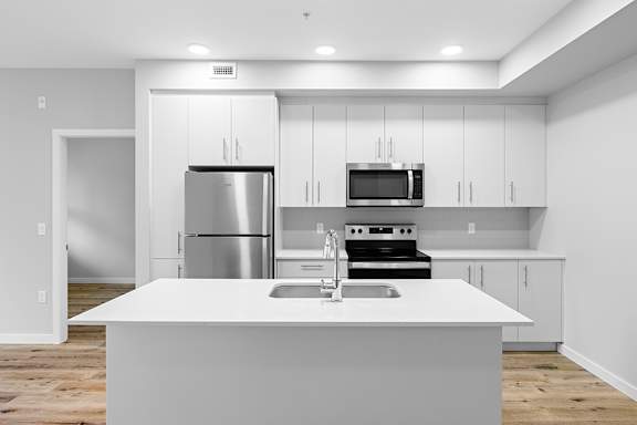 A modern kitchen with stainless steel appliances and white cabinetry.