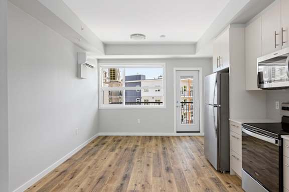 A kitchen with a refrigerator, microwave, and oven.