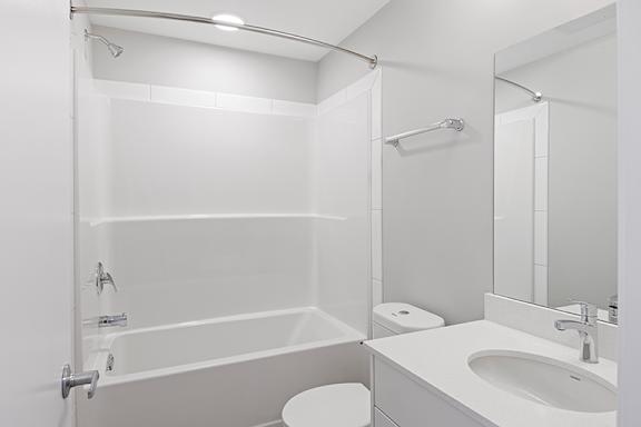 A white bathroom with a toilet, sink, and bathtub.
