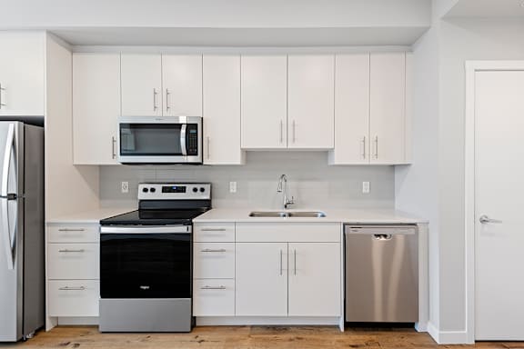 A kitchen with white cabinets and appliances.
