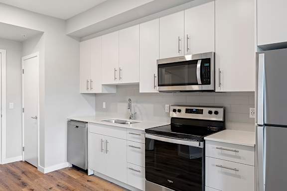 A kitchen with white cabinets and stainless steel appliances.
