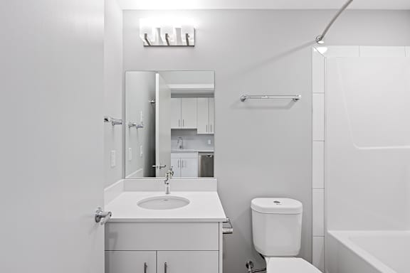 A white bathroom with a sink, toilet, and bathtub.