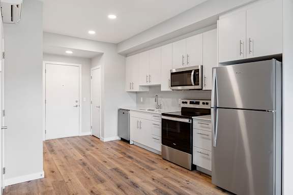 A kitchen with stainless steel appliances and white cabinets.
