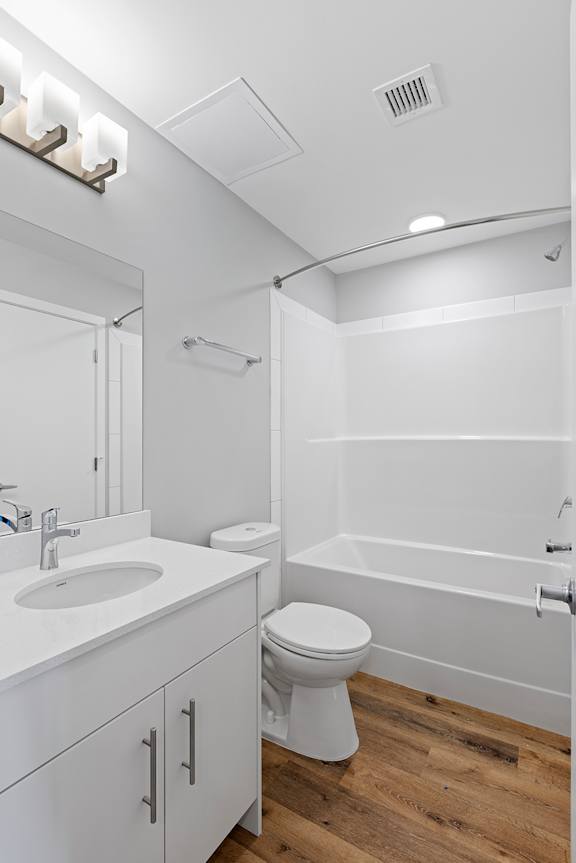 A white bathroom with a toilet, sink, and bathtub.