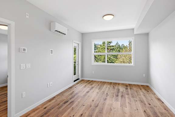A room with a window and a wall-mounted air conditioner.