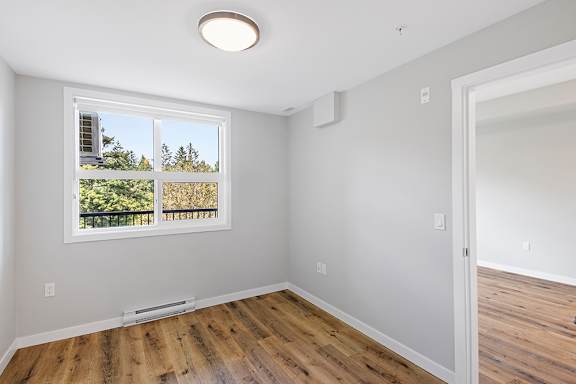 A room with a window overlooking a green area.