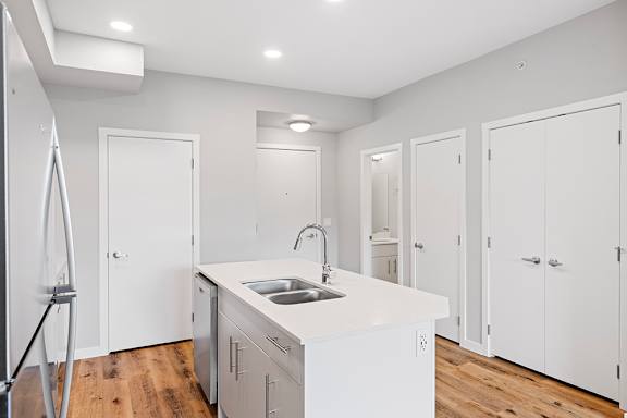 A white kitchen with a sink and cabinets.