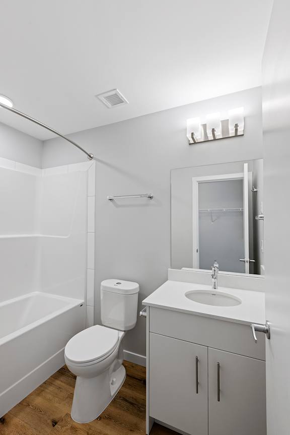 A white bathroom with a toilet, sink, and bathtub.
