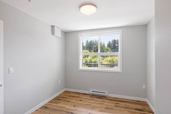 A room with a window showing trees outside.