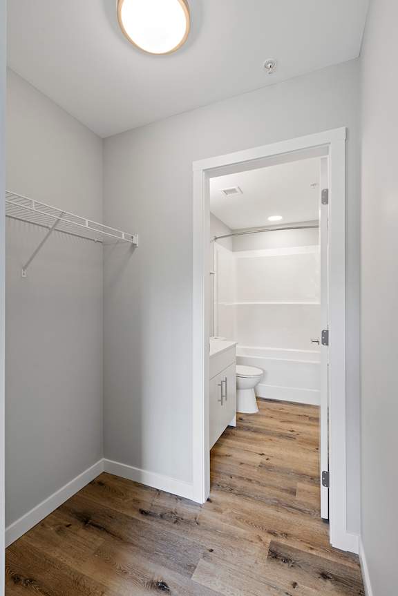 A white bathroom with a toilet and a walk-in shower.