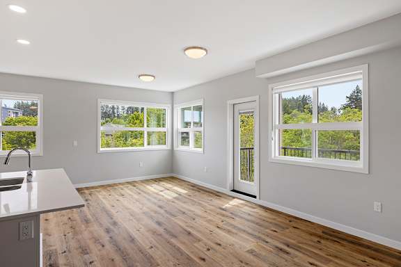 A kitchen with a sink and a window overlooking a green landscape.