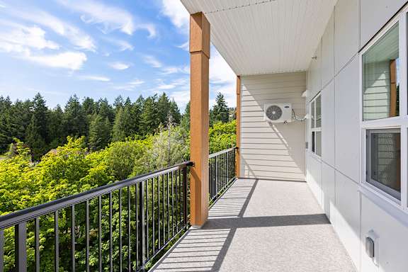 A balcony with a metal railing and a white wall.