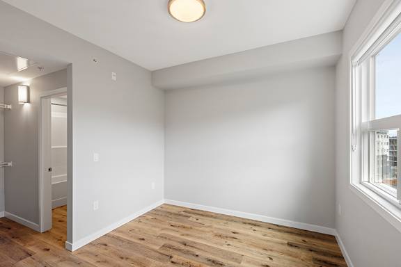 A room with wooden flooring and white walls.