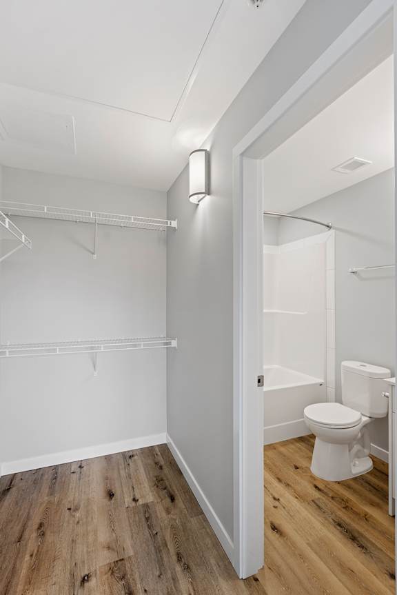 A white bathroom with a toilet and a walk in shower.