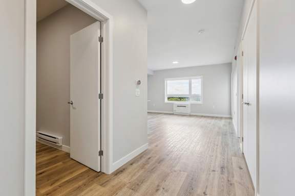 A white door is open to a room with a window.