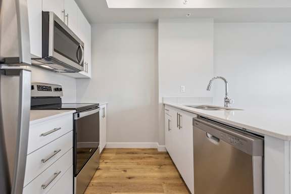 A modern kitchen with stainless steel appliances and white cabinets.