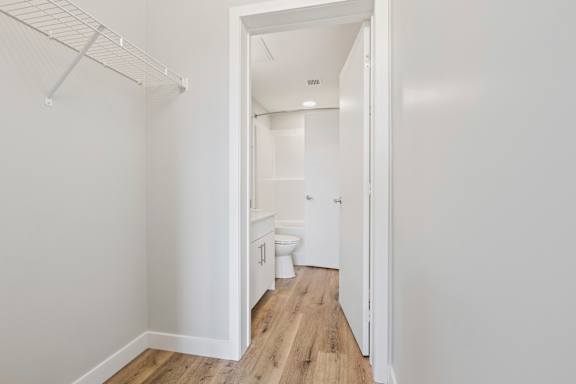 A white bathroom with a toilet, sink, and a walk-in shower.