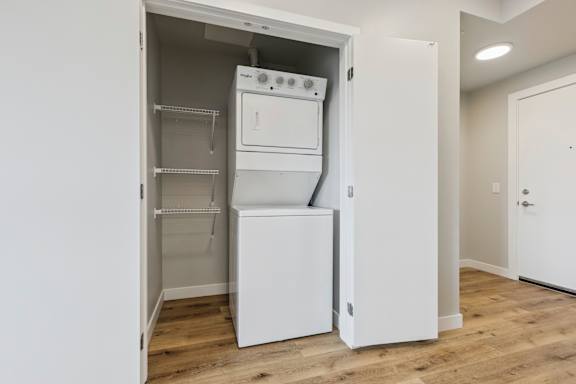 A white kitchen with a refrigerator, oven, and microwave.