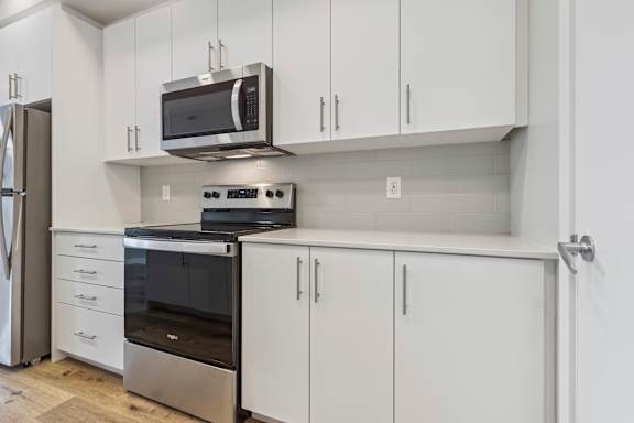 A kitchen with white cabinets and stainless steel appliances.