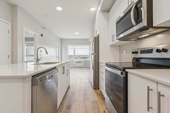 A modern kitchen with stainless steel appliances and white cabinets.