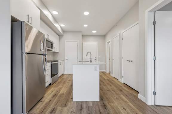 A modern kitchen with stainless steel appliances and white cabinetry.