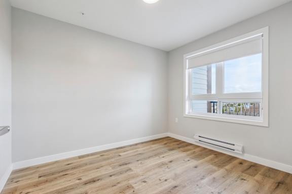A room with a window and a radiator on the floor.