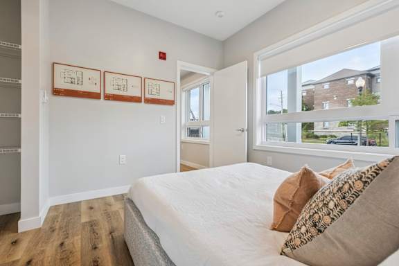 A bedroom with a large bed and a window overlooking a street.