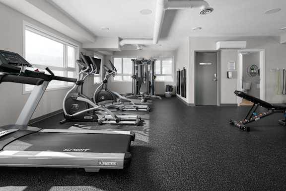 A gym with treadmills, elliptical machines, and other exercise equipment.