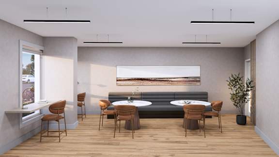 A modern living room with a grey sofa, wooden chairs, and a large painting on the wall.