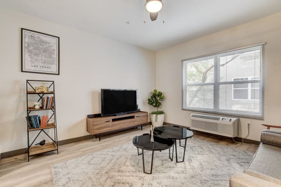 a living room with white walls and hardwood floors at The Vine on 8th, Las Vegas