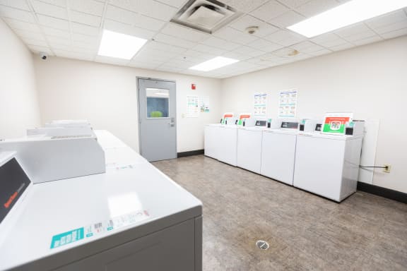 a laundry room with washers and dryers and a door to a hallway at ParcOne60, Reno, NV