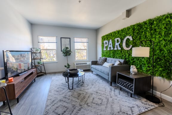 a living room with a green wall with a couch and a tv at ParcOne60, Nevada