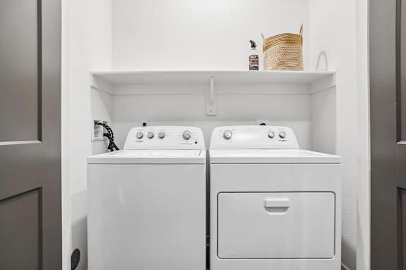 A white washing machine and dryer in a small laundry room.
