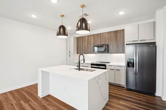 A modern kitchen with a white island and stainless steel appliances.