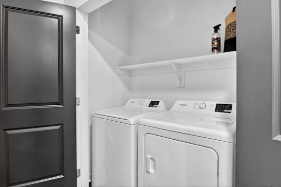 A white washing machine and dryer in a small laundry room.at The Logan Luxury Apartments, Idaho, 83651