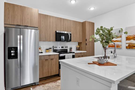 A modern kitchen with a white countertop and stainless steel appliances.at The Logan Luxury Apartments, Idaho, 83651