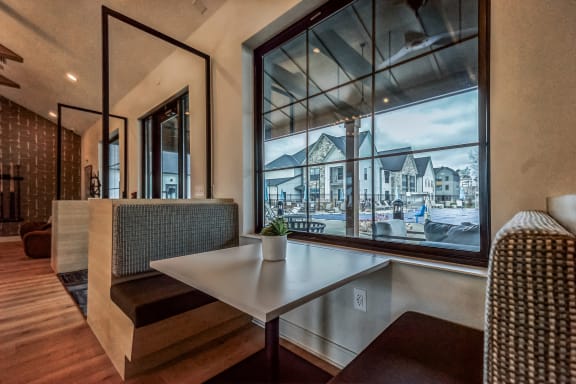 a dining room with a large window and a table at The BLVD at Wilson Crossings, Wyoming Michigan