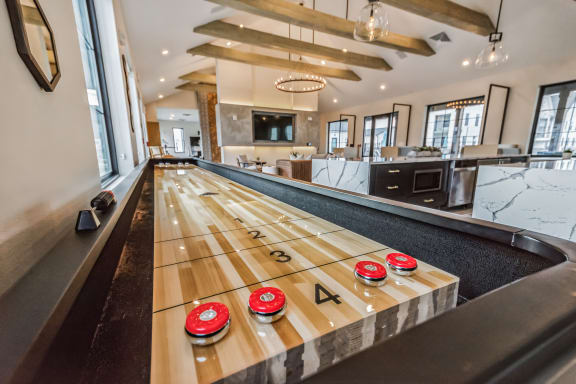 a shuffleboard table in the middle of a game room at The BLVD at Wilson Crossings, Wyoming, MI