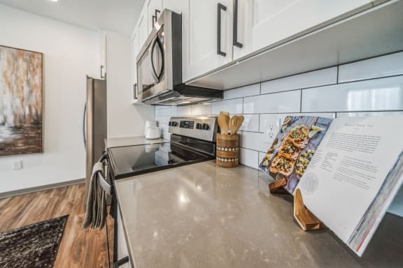 an updated kitchen with stainless steel appliances and white cabinets at The BLVD at Wilson Crossings, Wyoming