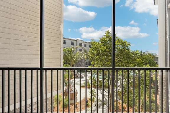 A view from a balcony looking out at a courtyard with a building in the background at The Stadler Luxury Apartments, Bradenton, Florida