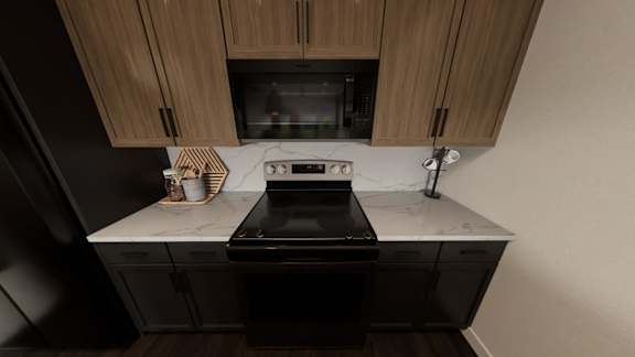 A kitchen with a black stove top oven and wooden cabinets.