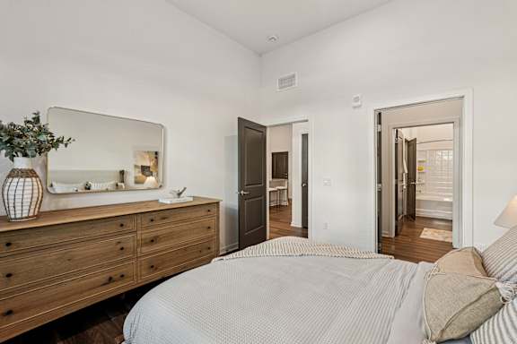 A bedroom with a bed, dresser, and mirror at The Stadler Luxury Apartments, Bradenton, FL