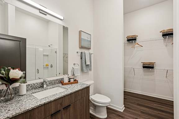 A bathroom with a toilet, sink, and mirror at The Stadler Luxury Apartments, Florida 34210